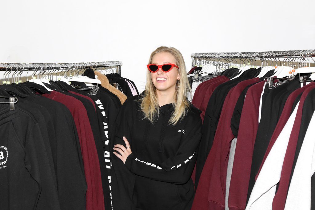 Emma Benneyworth is photographed standing with racks of Brunette the Label clothing.
