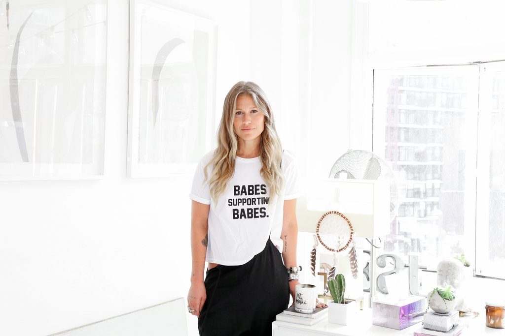 Kate Horsman is photographed standing in her home in Vancouver while wearing the Babes Supporting Babes Cropped Tee by Brunette the Label.