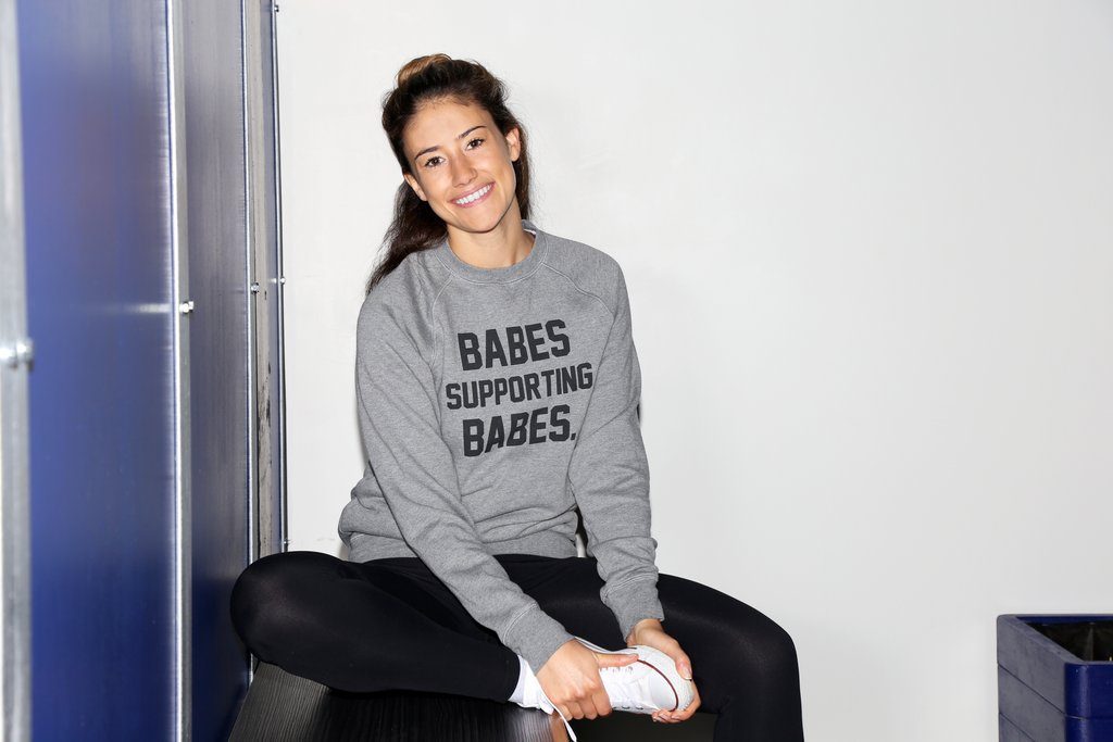 Female entrepreneur Naomi White is photographed smiling and wearing a Brunette the Label sweatshirt.