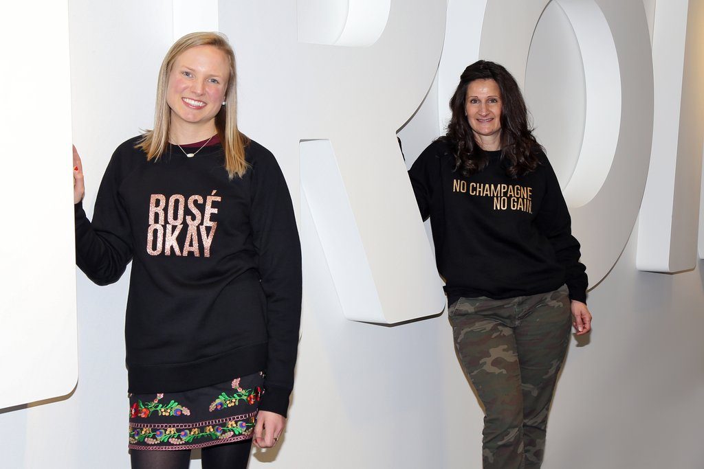 Two members of the Nordstrom Sleepwear Buying Team are photographed standing in front of the Nordstrom office logo.