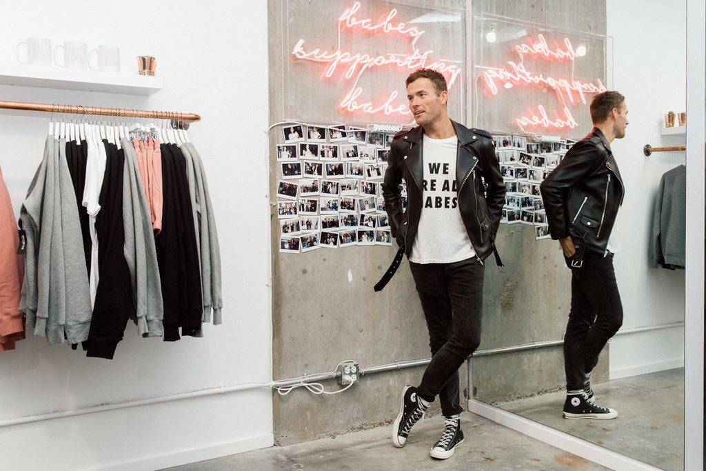 Ryan Pugsley is photographed standing in front of the Babes Supporting Babes wall at the Brunette the Label Flagship Store.