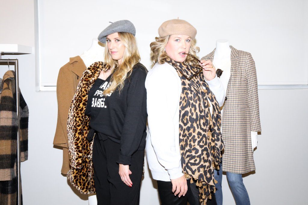 Female fashion entrepreneurs Susan Cooper and Heather Jansen are photographed standing with mannequins at the Susan Cooper Agency.