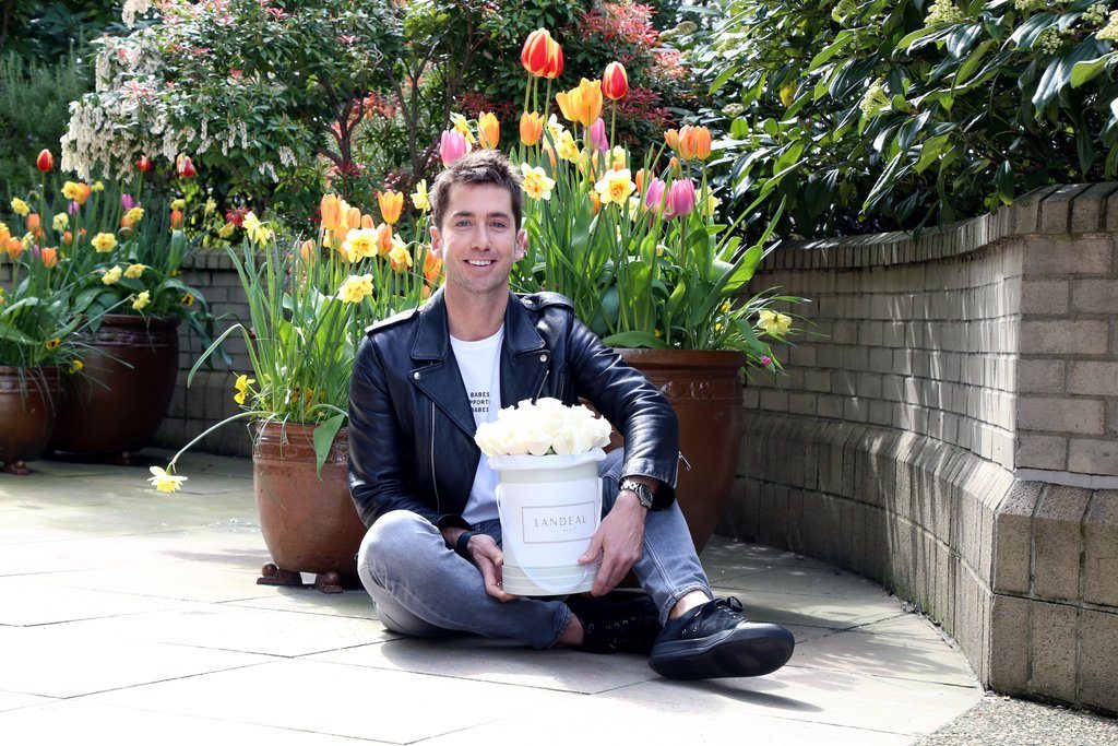 Trevor Patterson is photographed sitting in Vancouver with a bouquet of Landeau roses. 