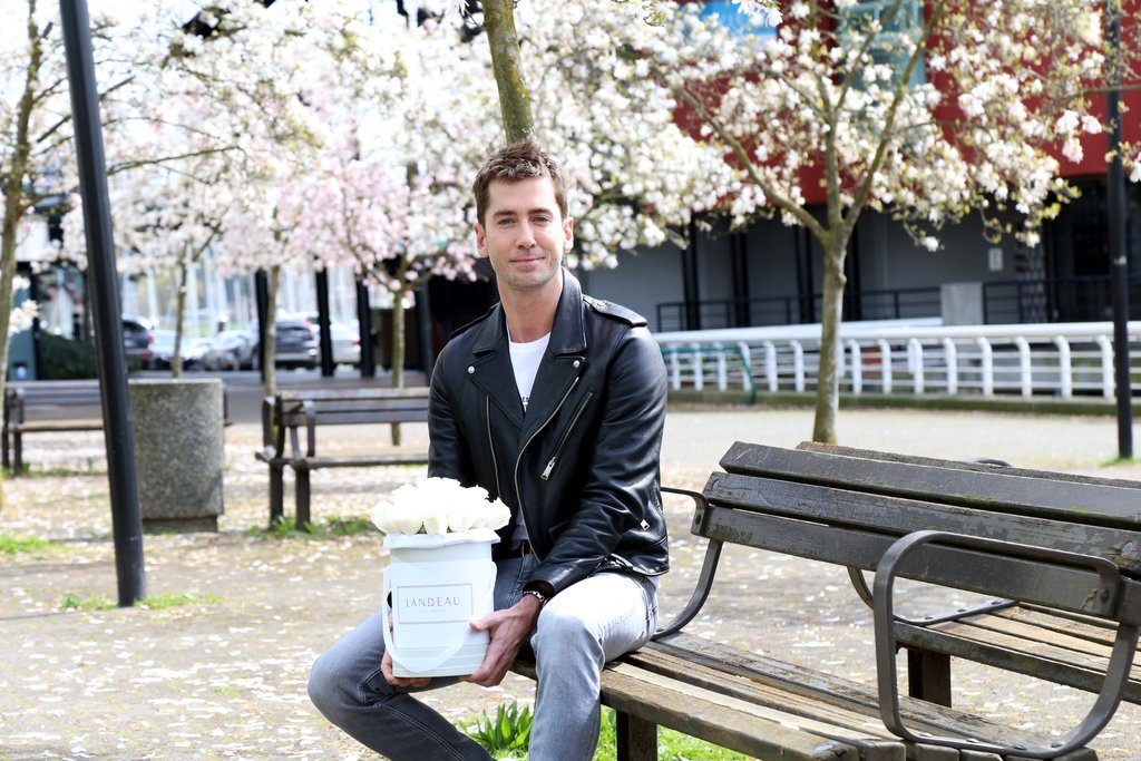 Trevor Patterson is photographed sitting on a bench holding Landeau roses in Vancouver.