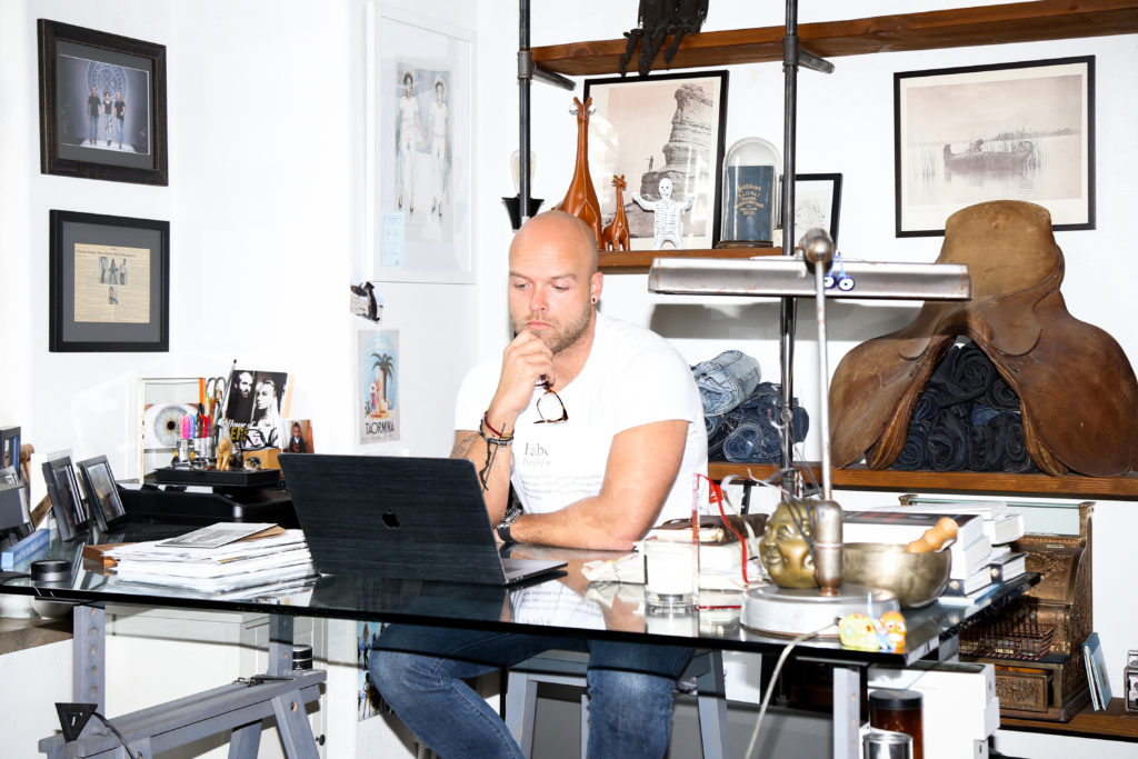 Adam Taubenfligel is photographed working at the office of his sustainable denim line, Triarchy.