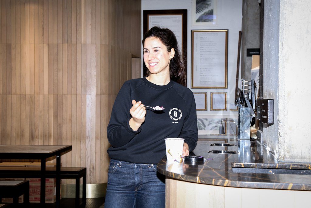 Lia Loukas is photographed eating ice cream at plant-based restaurant, Virtuous Pie.