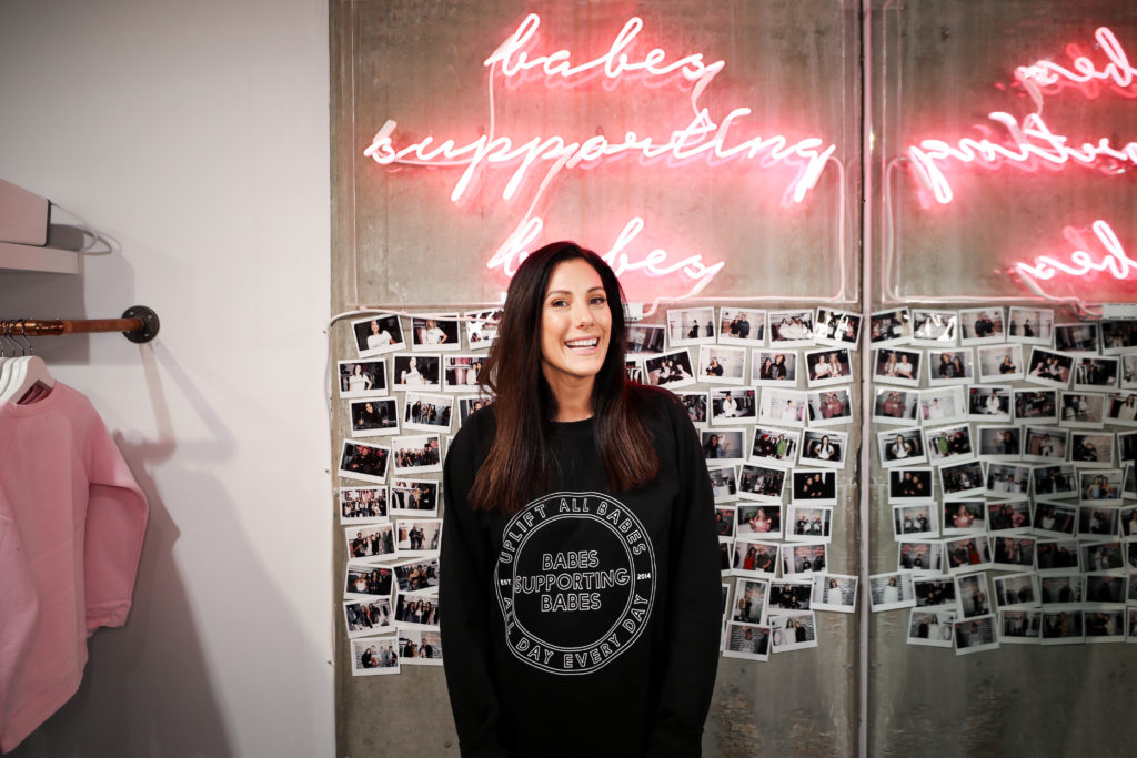 Female entrepreneur Miriam Alden of Brunette the Label is photographed standing in front of the Babes Supporting Babes sign at her Vancouver store.