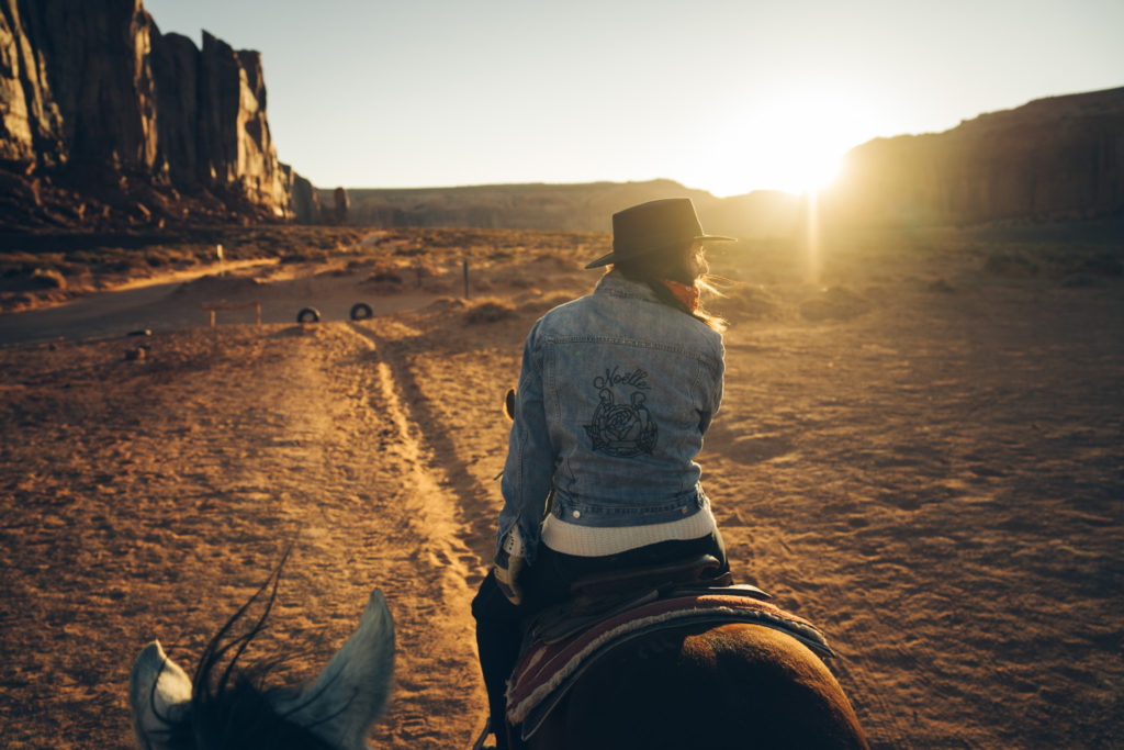 Noëlle Floyd, the female entrepreneur behind Noëlle Floyd Magazine is photographed riding a horse in the desert. 