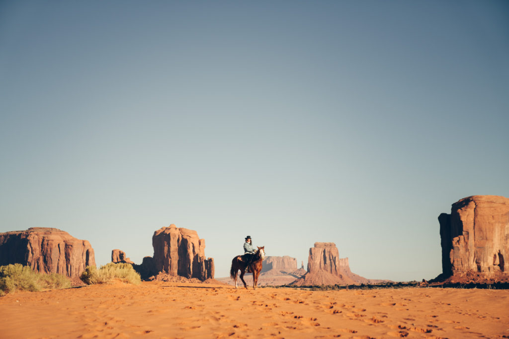 Noëlle Floyd, the female entrepreneur behind Noëlle Floyd Magazine is photographed on a horse in the desert. 